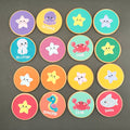 Colourful wooden discs with sea creatures painted on them. On a black surface