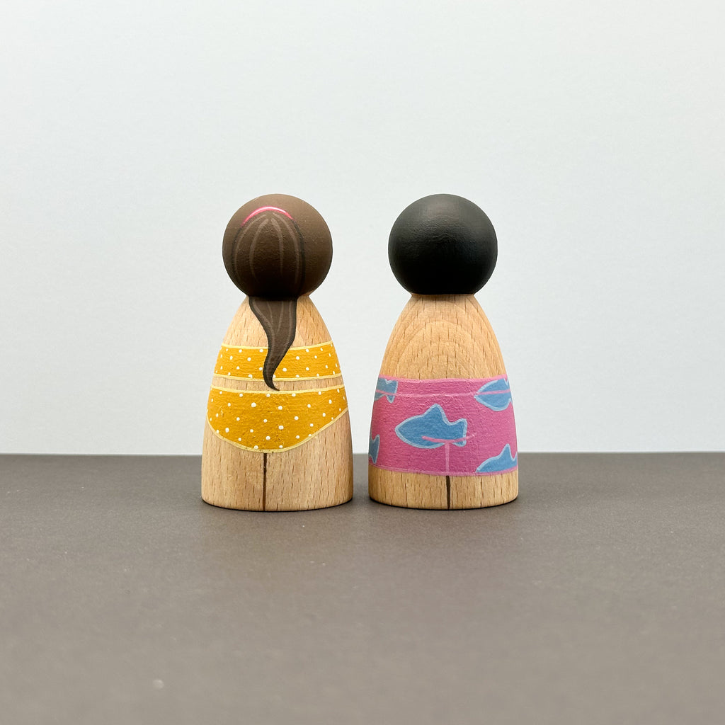 Two wooden peg dolls in swimwear