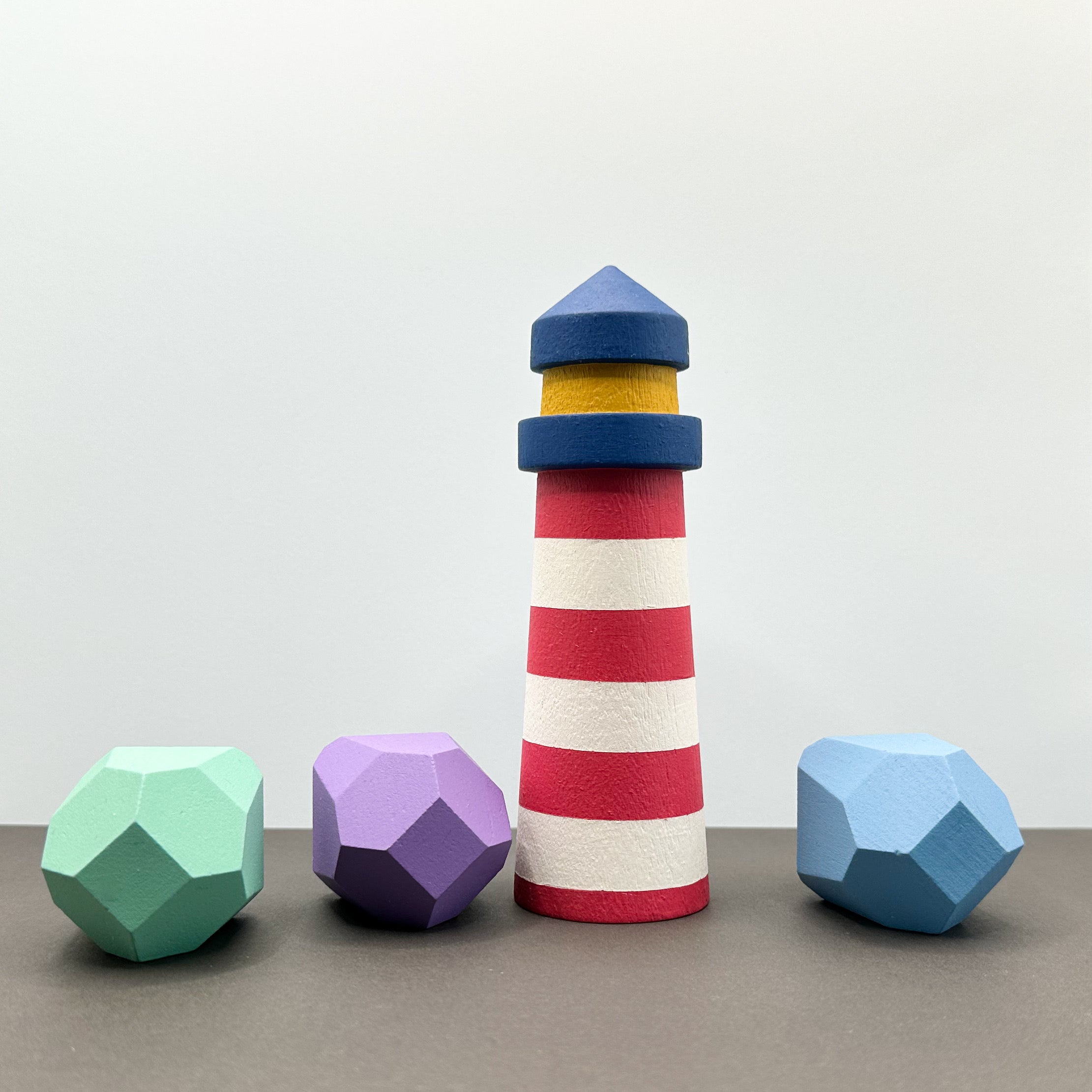 A wooden lighthouse with three wooden rocks