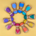 Wooden Dolls with colorful hats arranged in a circle on a yellow background. The dolls have colourful painted shapes on their tummies. 