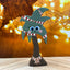 Decorative palm tree figurine with candy cane ribbbon on a wooden surface with blurred lights in the background