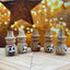 Set of wooden snowman figurines with painted faces on a wooden surface with a warm, blurred background.