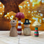 Wooden figurines with colorful mushrooms  on a wooden surface with a warm, blurred background.