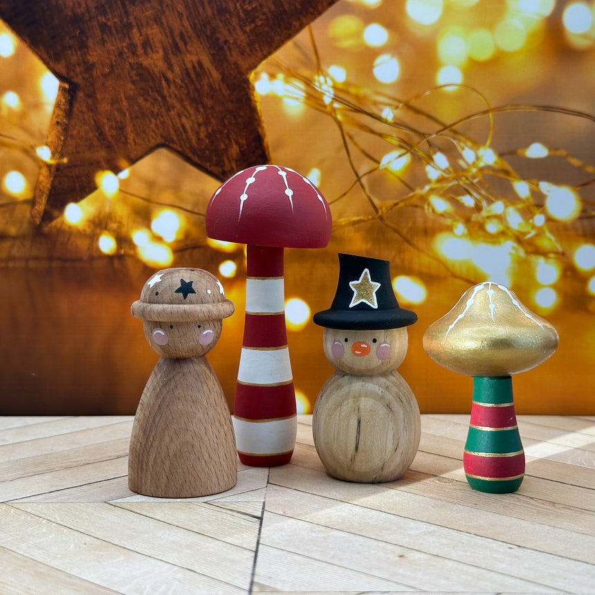 Wooden figurines with colorful mushrooms  on a wooden surface with a warm, blurred background.